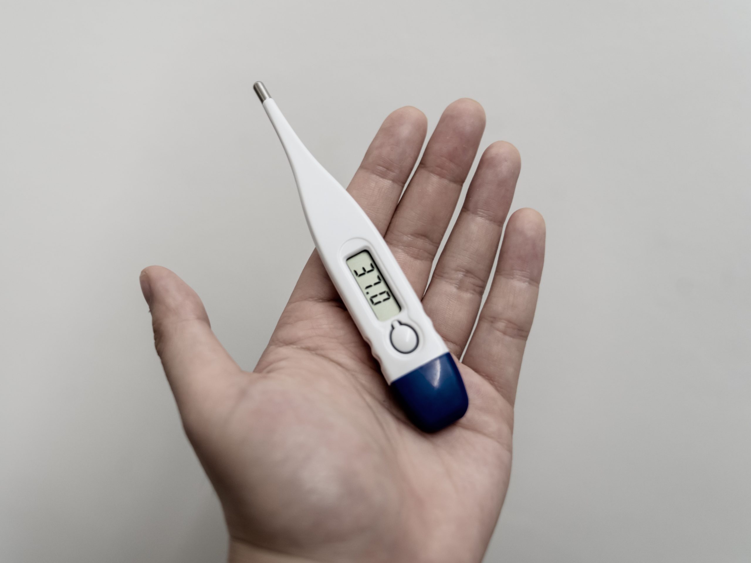 Hand holding a digital thermometer